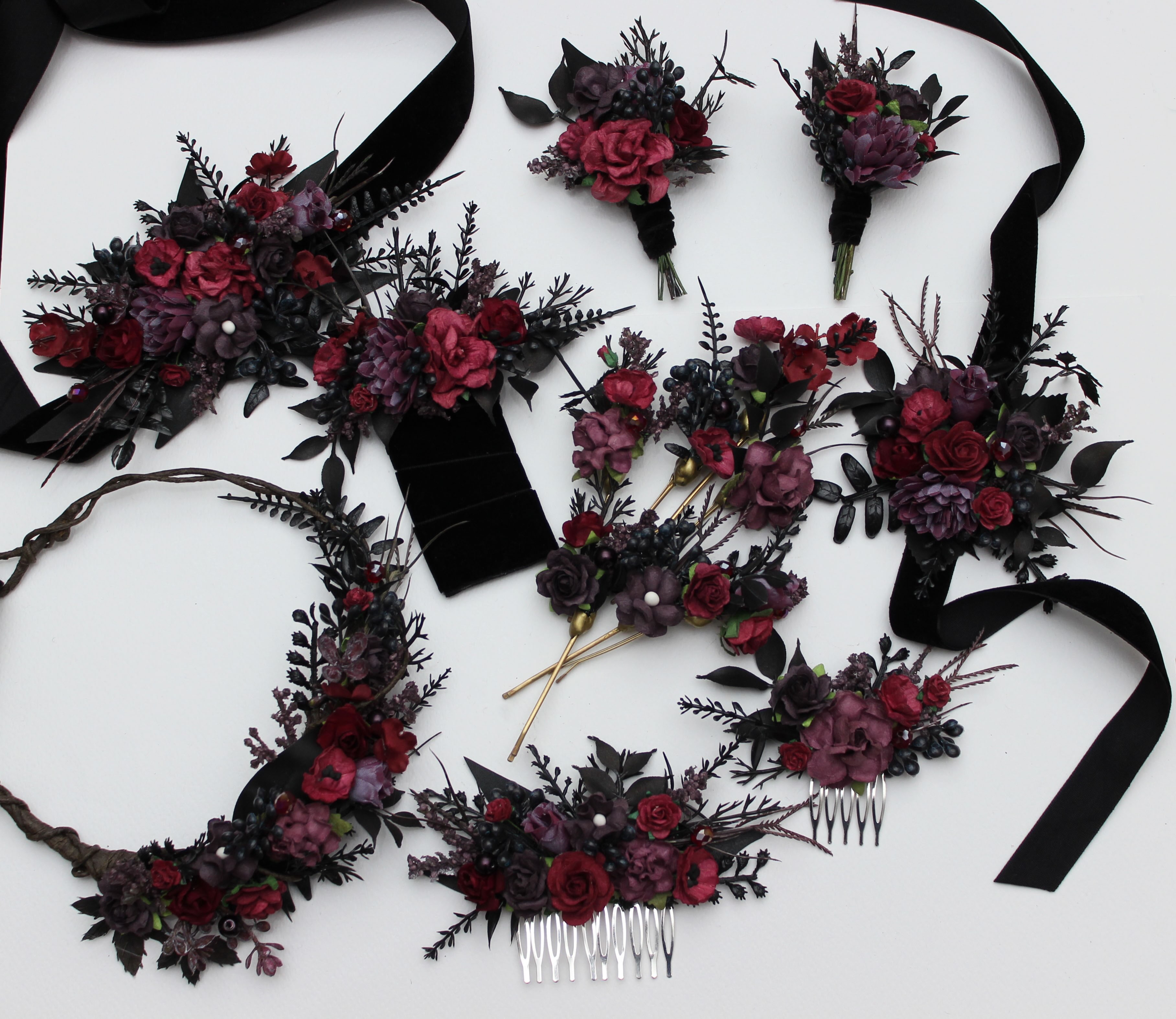 A moody collection of gothic-inspired wedding accessories, featuring deep burgundy, dark plum, and obsidian black tones 
